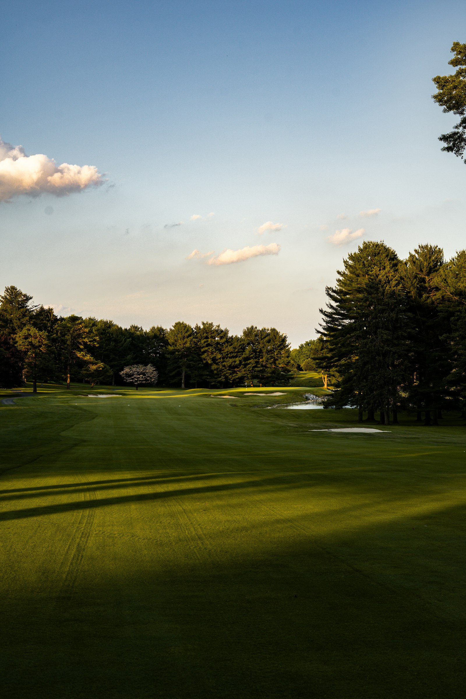 View across a manicured golf course fairway toward the green and surrounding landscape